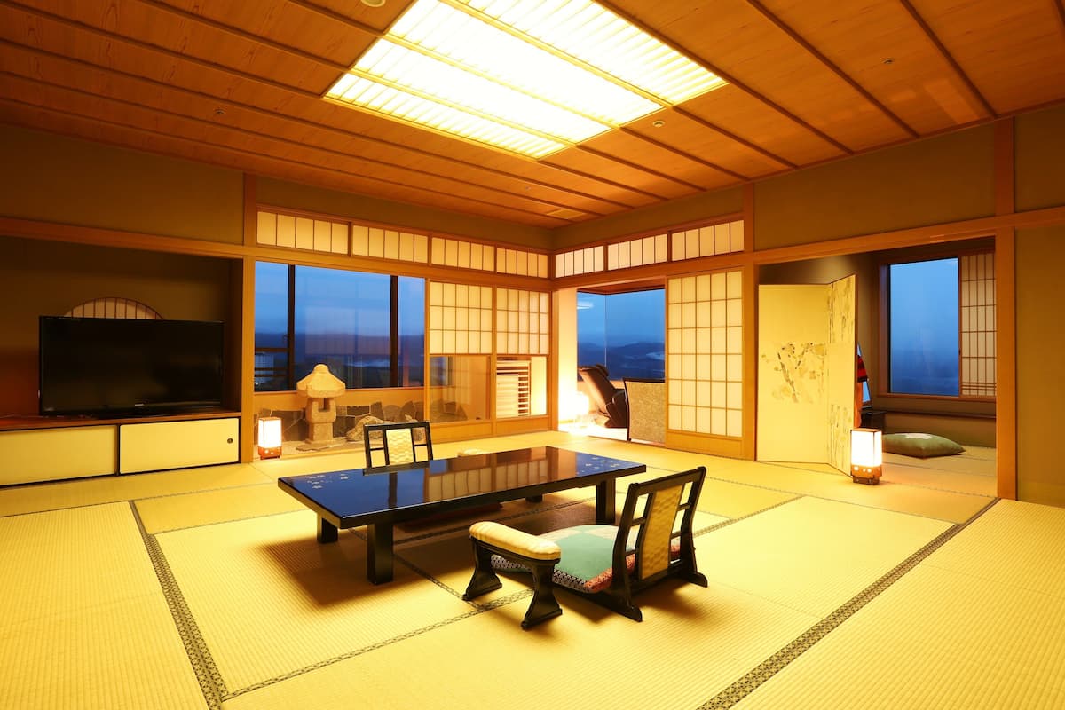 Une pièce de style japonais traditionnel, avec un sol recouvert de tatamis, une table basse et des portes coulissantes.