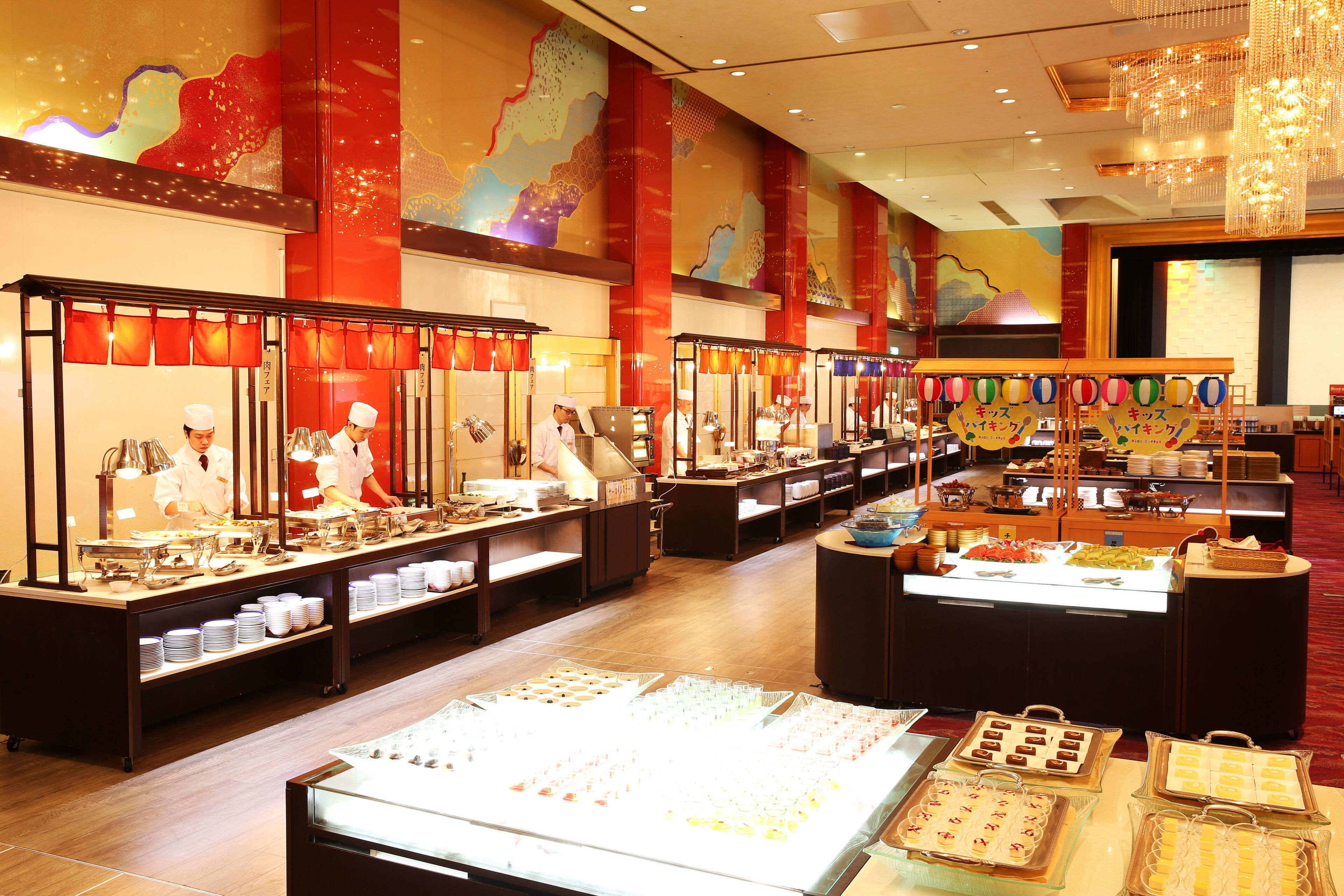 A buffet area with multiple food stations and a variety of dishes displayed in glass cases.
