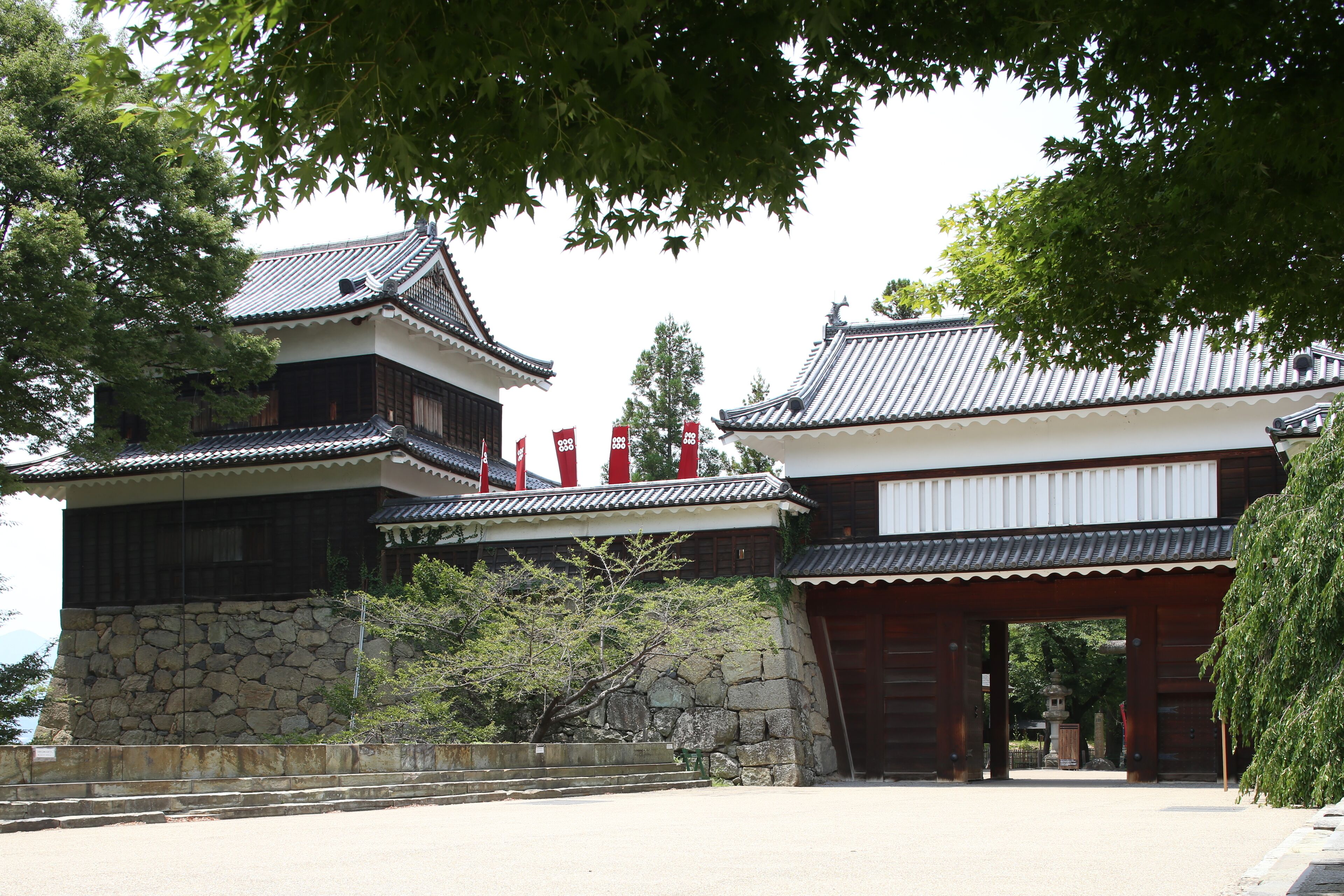 Ein traditionelles japanisches Gebäude mit einer Steinwand und Holztüren.
