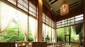 Una habitación amplia con ventanas grandes, muebles de madera y un candelabro.