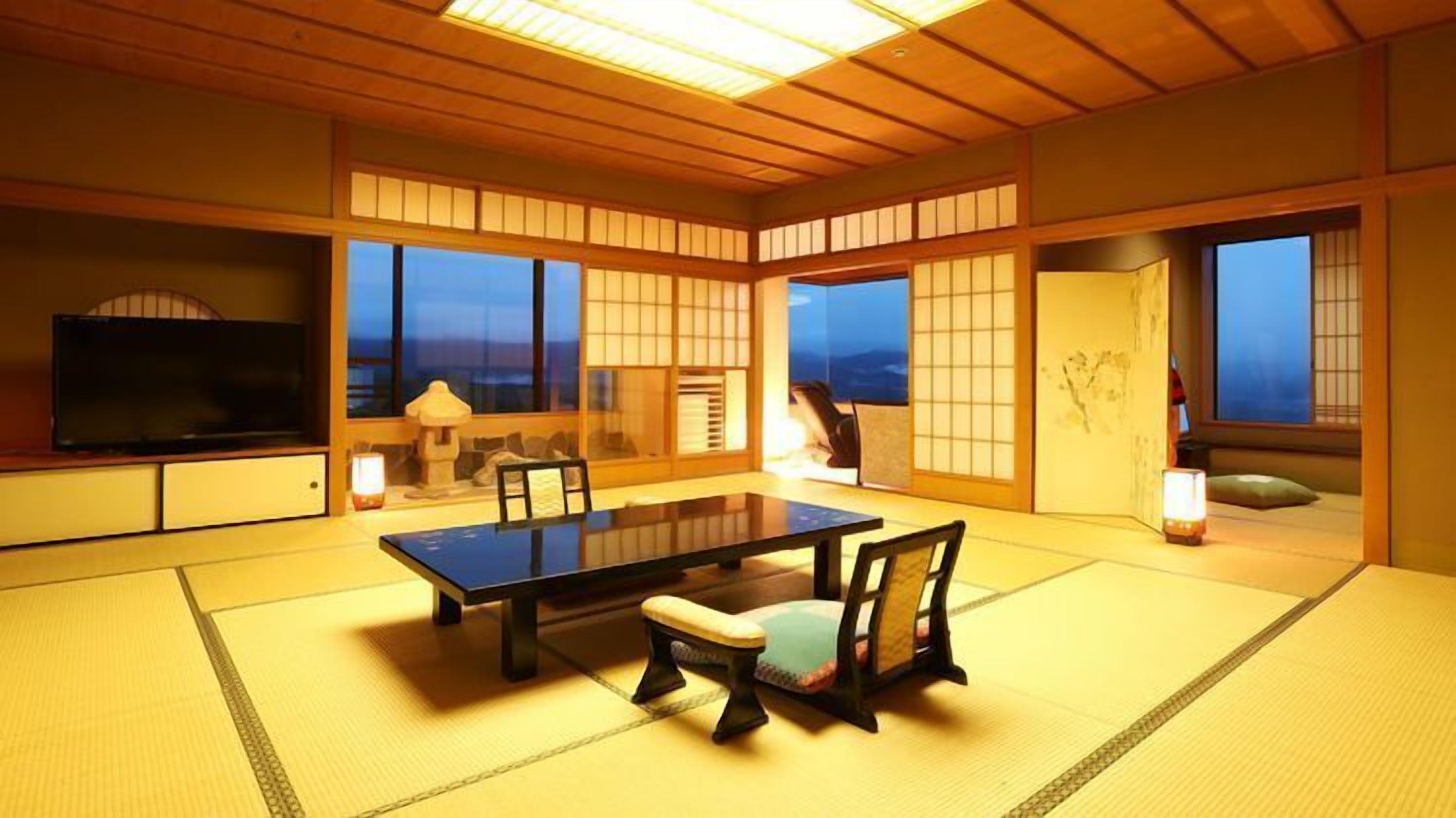 A traditional Japanese room with tatami flooring, a low table, and chairs.