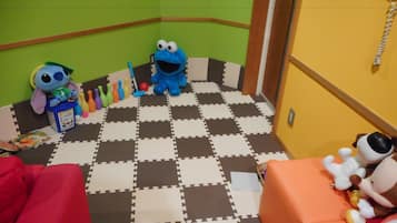 Children can play and relax in this fun play area with a checkered floor, plush toys, and a table with bowling pins.