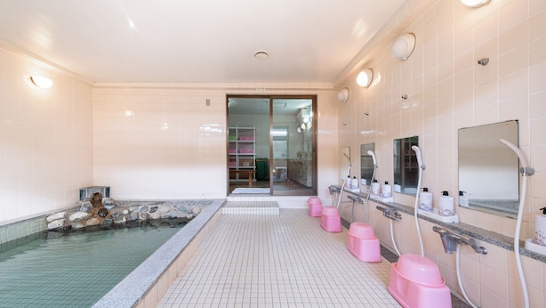 A bathroom with a tiled floor, a small pool, and multiple sinks with mirrors. - Fujizakura Onsen Ryokan (Fuefuki)