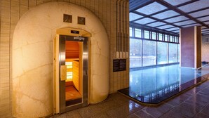 An indoor swimming pool with a sauna area, a reception desk, and a large window providing natural light. - Ooedo Onsen Monogatari Premium Yamashitaya (Kaga)