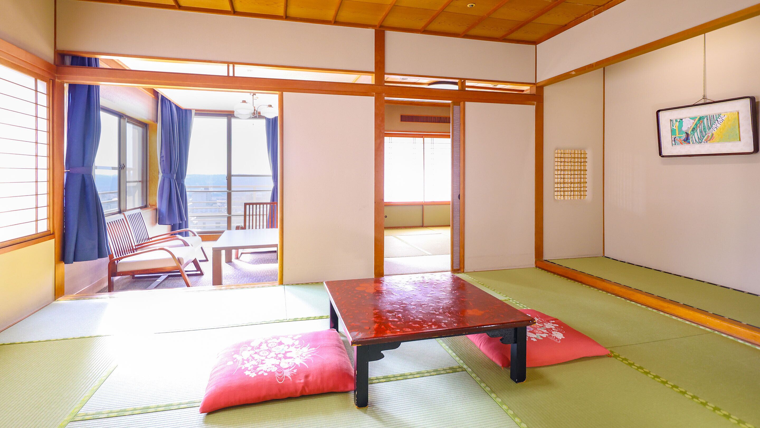 Une pièce de style japonais traditionnel, avec un sol recouvert de tatamis, une table basse et une vue sur l’extérieur.