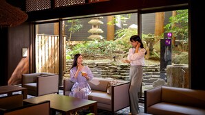 A traditional Japanese-style room with tatami flooring, a stone lantern, and a view of a garden with a pagoda. - Ooedo Onsen Monogatari Premium Yamashitaya (Kaga)