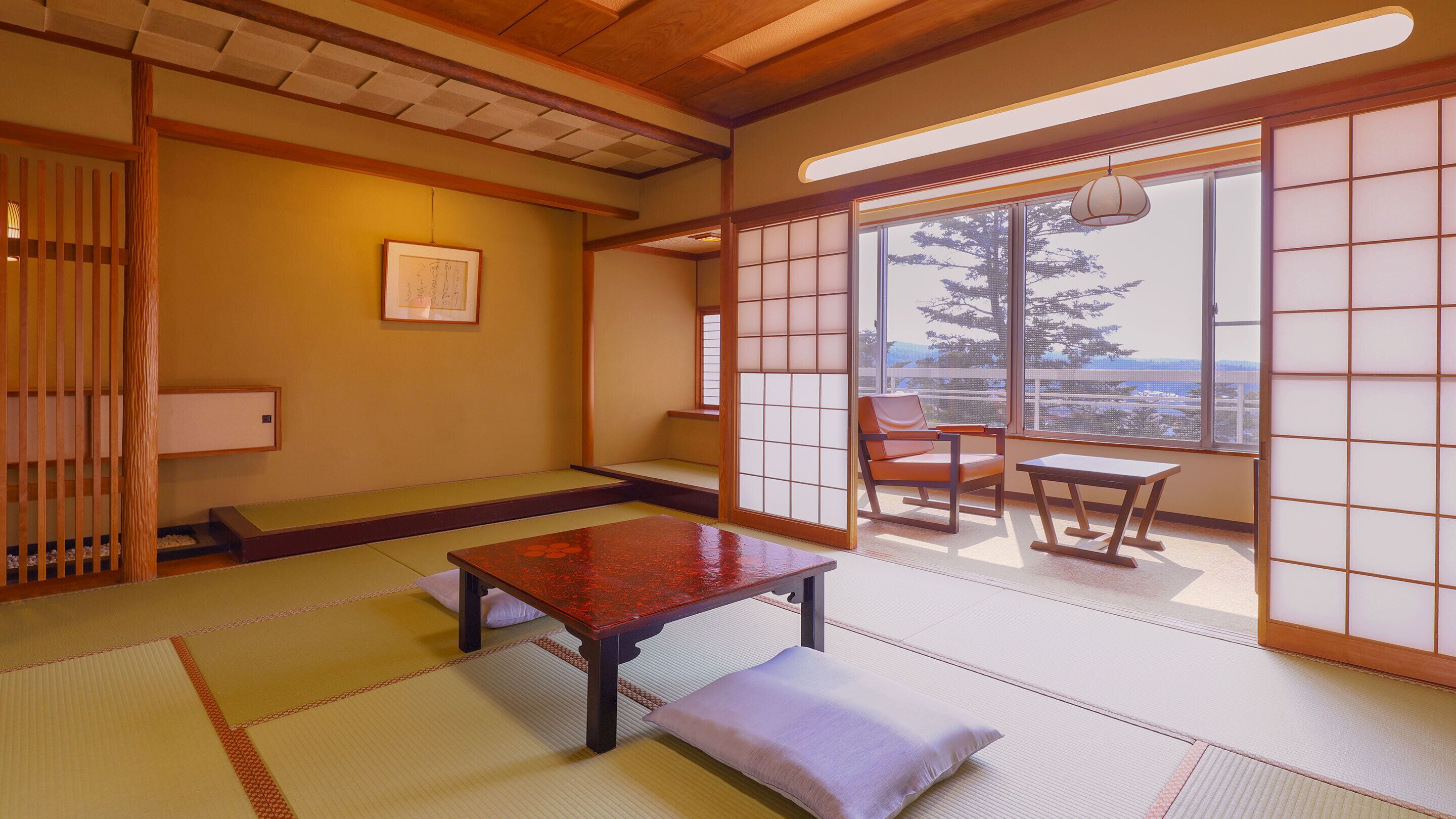 Une pièce de style japonais traditionnel, avec un sol recouvert de tatamis, une table basse, un banc rembourré et une porte coulissante donnant sur l’extérieur.