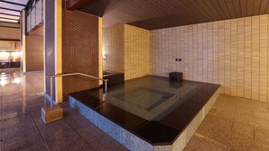 A modern indoor pool area with a glass floor, a metal railing, and a tiled wall with a geometric pattern. - Ooedo Onsen Monogatari Premium Yamashitaya (Kaga)