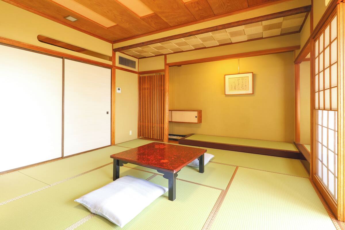 A traditional Japanese room with tatami flooring, a low wooden table, and shoji screens.