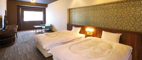 A hotel room with two beds, a desk, a chair, and a large window.