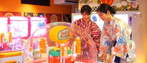A group of people interacting with a colorful, transparent vending machine labeled 'Sweet Land' in a brightly lit indoor setting.