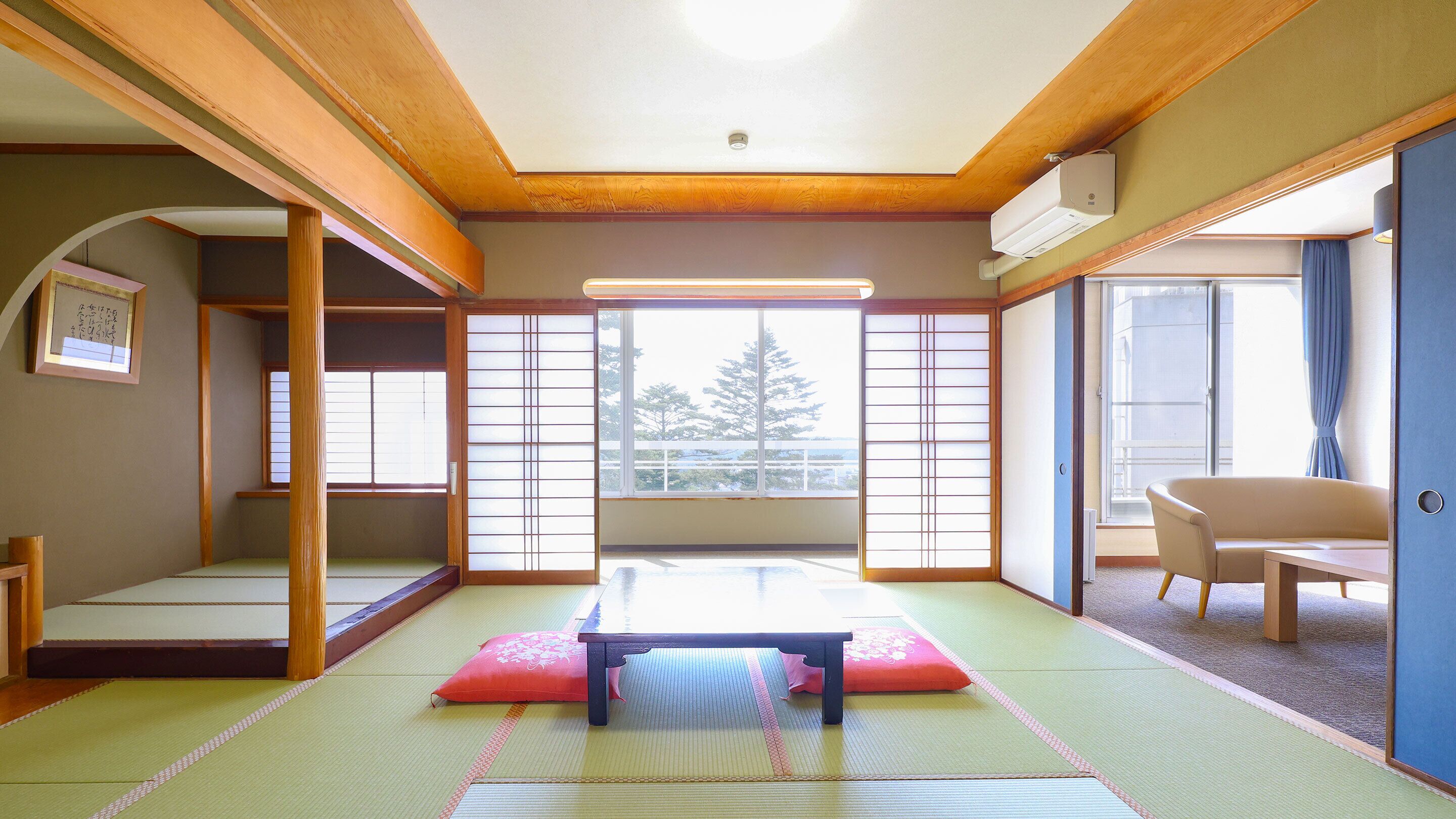 Une pièce de style japonais traditionnel, avec un sol recouvert de tatamis, une table basse et des portes coulissantes.