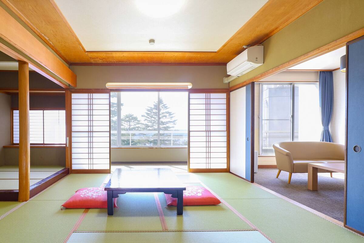 A traditional Japanese room with tatami flooring, a low table, and sliding doors.