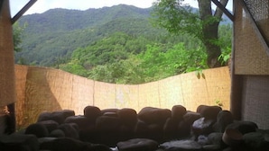 Une pièce offrant une vue sur un paysage montagneux, avec un mur en pierre et une structure en bois.