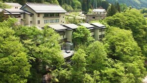 Un ensemble de b âtiments de style traditionnel, entourés d’une forêt dense.
