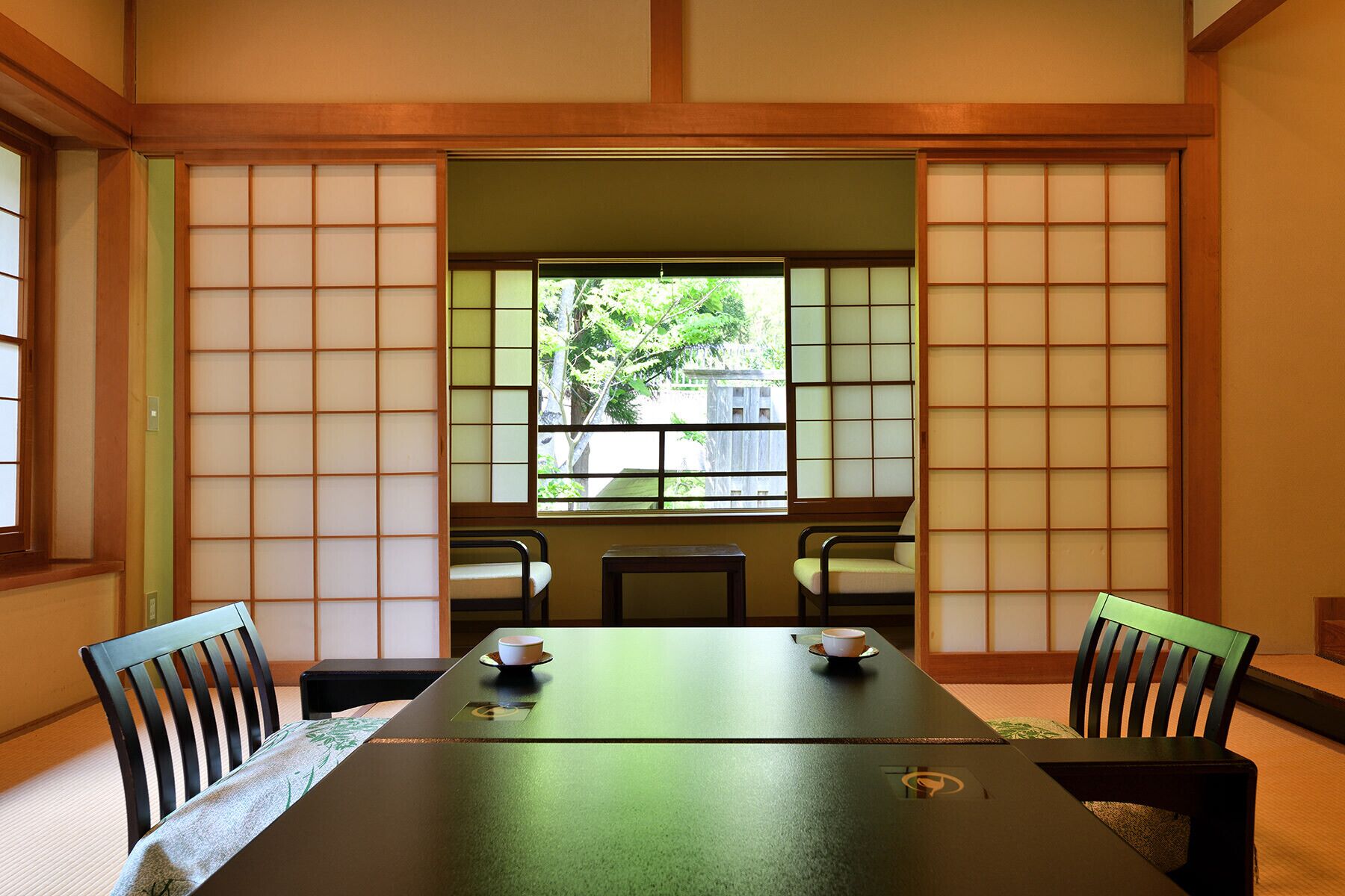 A traditional Japanese room with tatami flooring, a low table, and shoji screens.