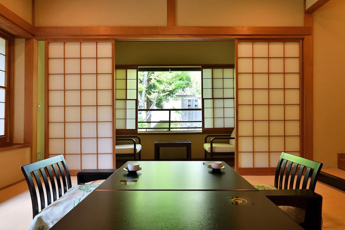 A traditional Japanese room with tatami flooring, a low table, and shoji screens.