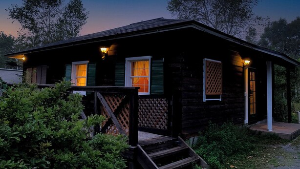 A small cabin with a porch, two windows with curtains, and a staircase leading up to the entrance. - Plaisir (Suzaka)