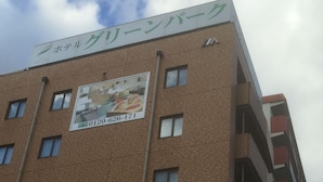 A multi-story hotel building with a sign indicating it is a hotel. - Hotel Green Park (Sendai)