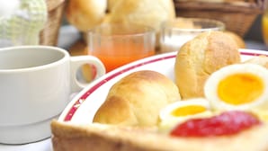 A breakfast setting with bread rolls, eggs, and a cup of tea. - Hotel Green Park (Sendai)