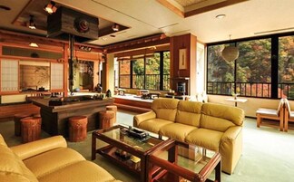A traditional Japanese-style living room with tatami flooring, a low table, and a sofa.
