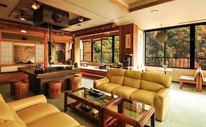 A traditional Japanese-style living room with tatami flooring, a low table, and a sofa. - Goroukaku (Numata)
