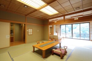 A traditional Japanese room with tatami flooring, a wooden table, and sliding doors.