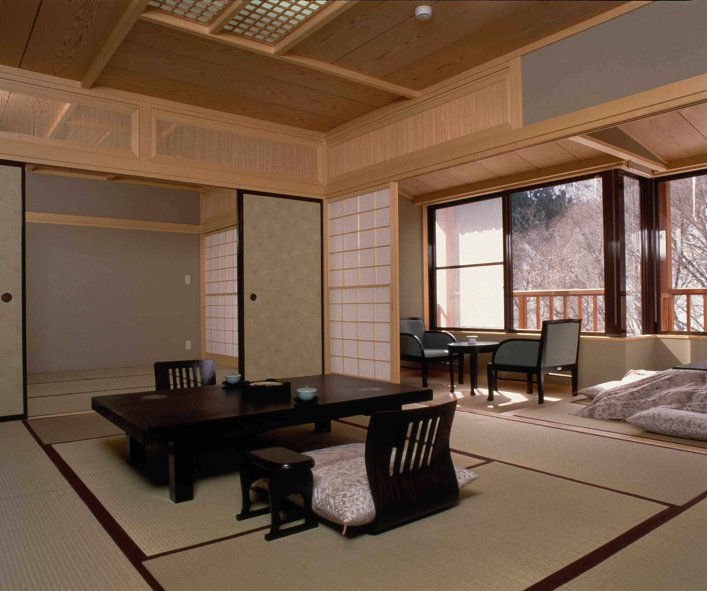 A traditional Japanese room with tatami flooring, a low table, and sliding doors.