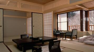 A traditional Japanese room with tatami flooring, a low table, and sliding doors.