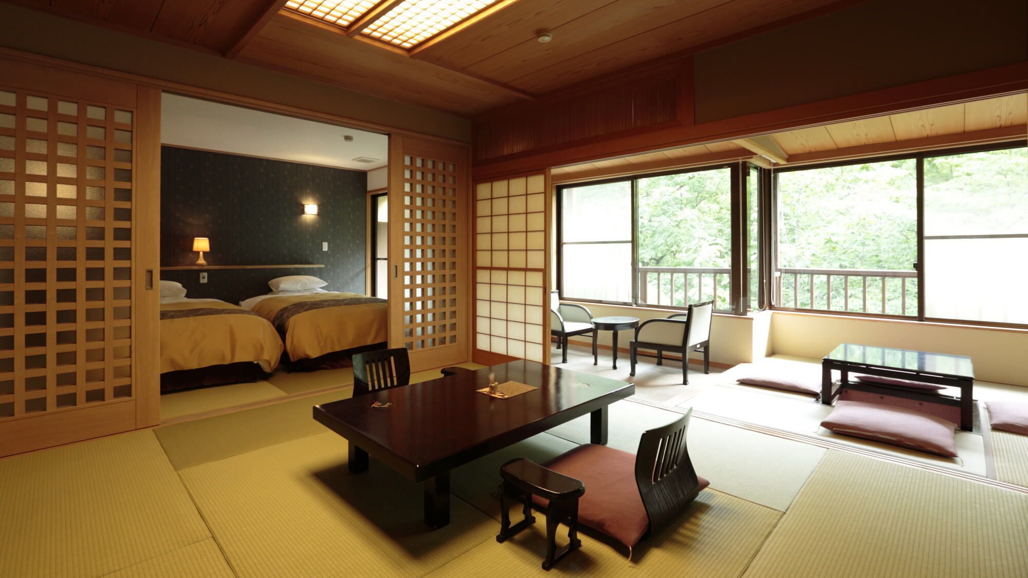 A traditional Japanese-style room with tatami flooring, a low table with cushions, and a sliding door.