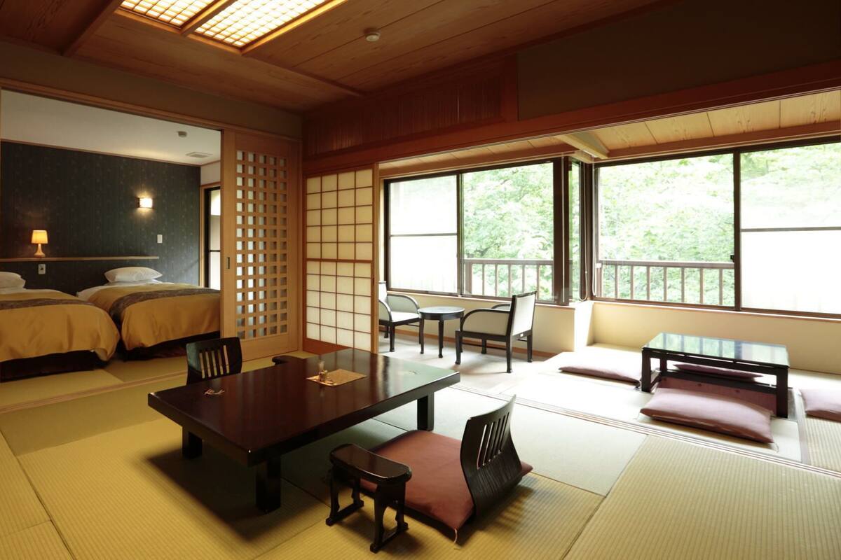 A traditional Japanese-style room with tatami flooring, a low table with cushions, and a sliding door.