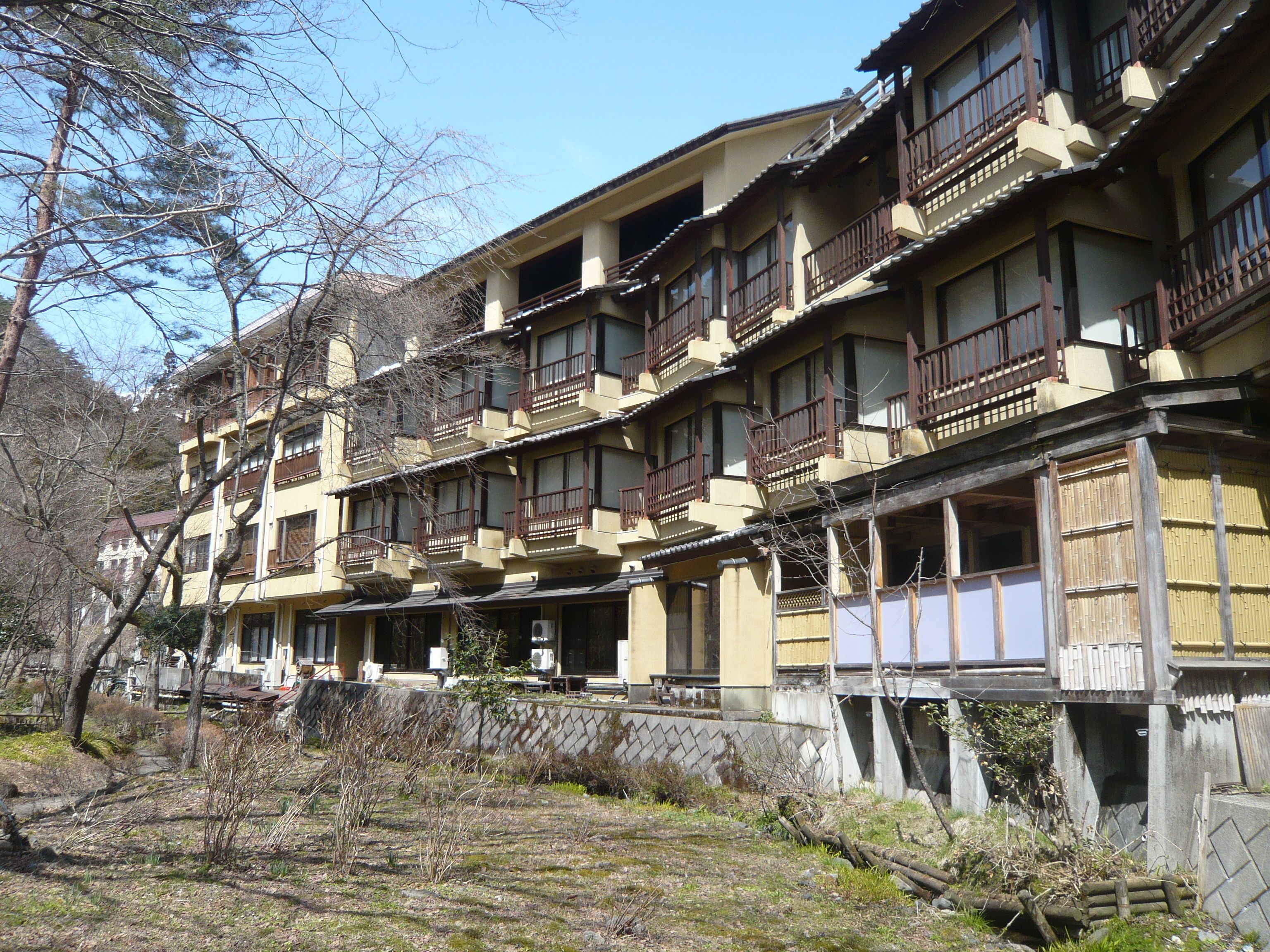 A multi-story building with traditional wooden balconies and a mix of open and closed windows.