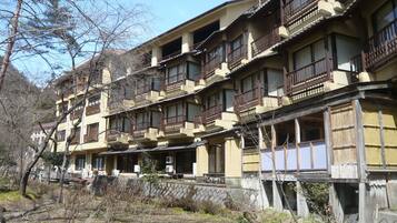 A multi-story building with traditional wooden balconies and a mix of open and closed windows.