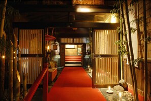 A traditional Japanese-style interior with a red carpet leading to a wooden door. - Honke Bankyu (Nikko)