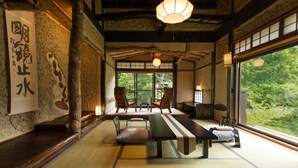 Una habitación japonesa tradicional con suelo de tatami, una mesa baja y sillas.