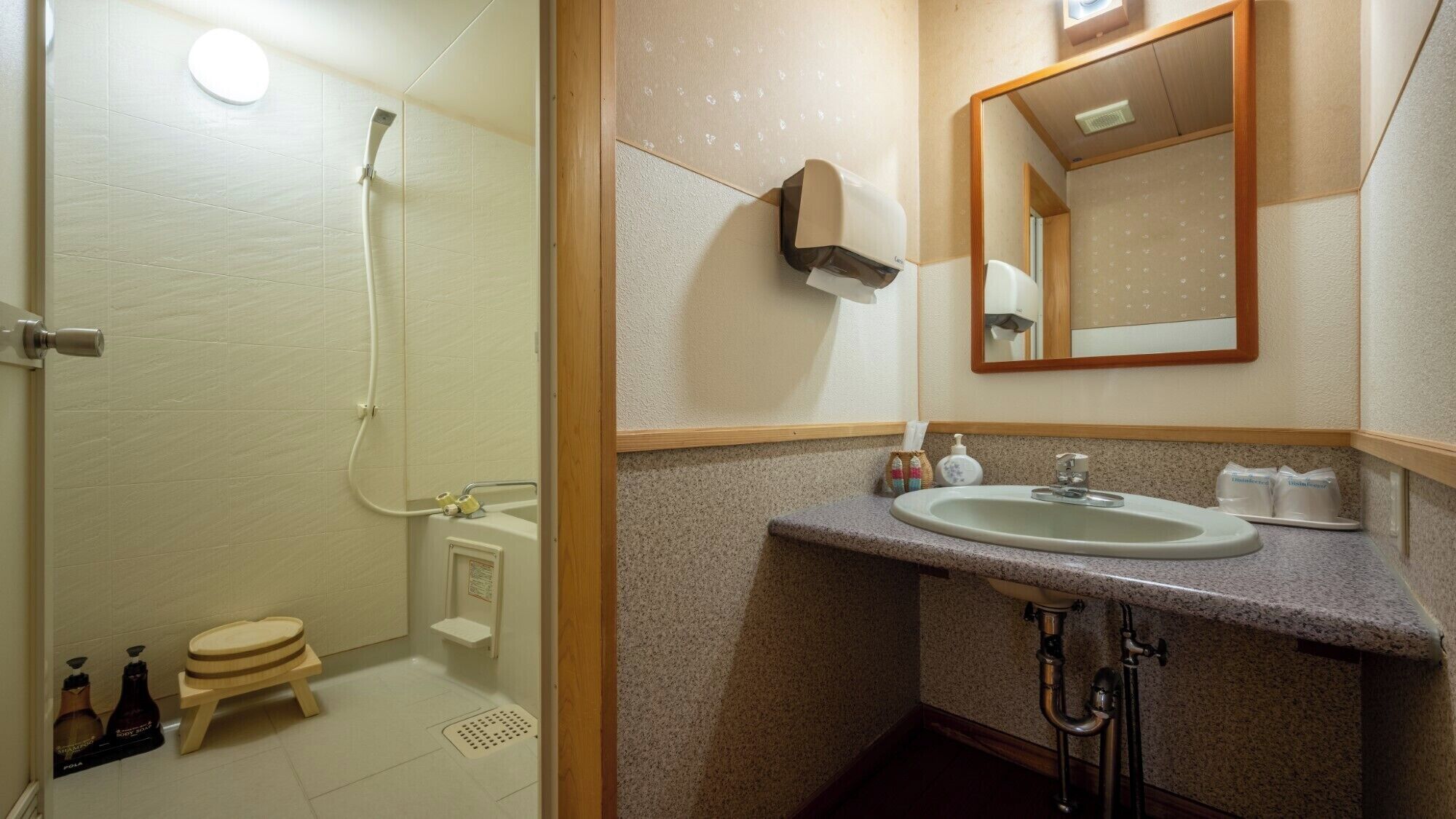 Une salle de bain équipée d’une douche, de toilettes, d’un lavabo et d’un miroir.