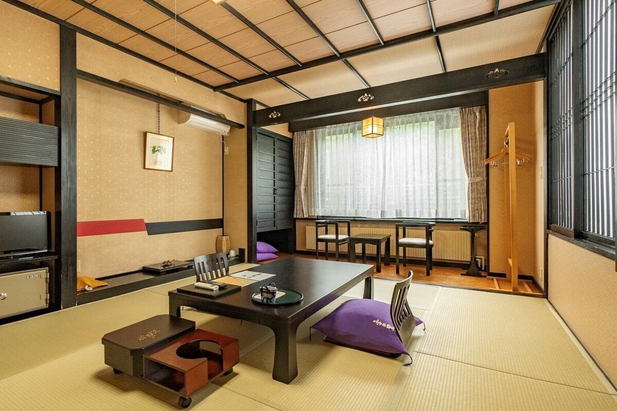 Een traditionele Japanse kamer met tatami vloerbedekking, een lage tafel en glijdende deuren.