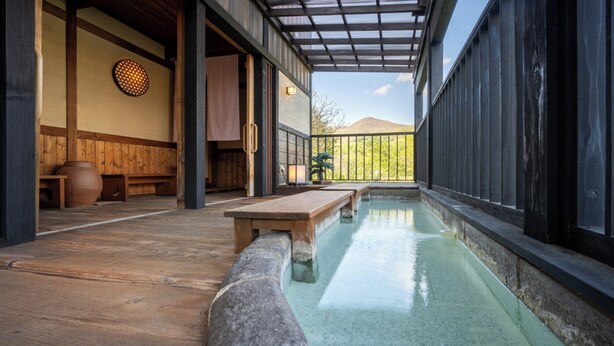 A traditional Japanese onsen with wooden benches and a stone bath. - Zao Onsen Kinosato (Yamagata)
