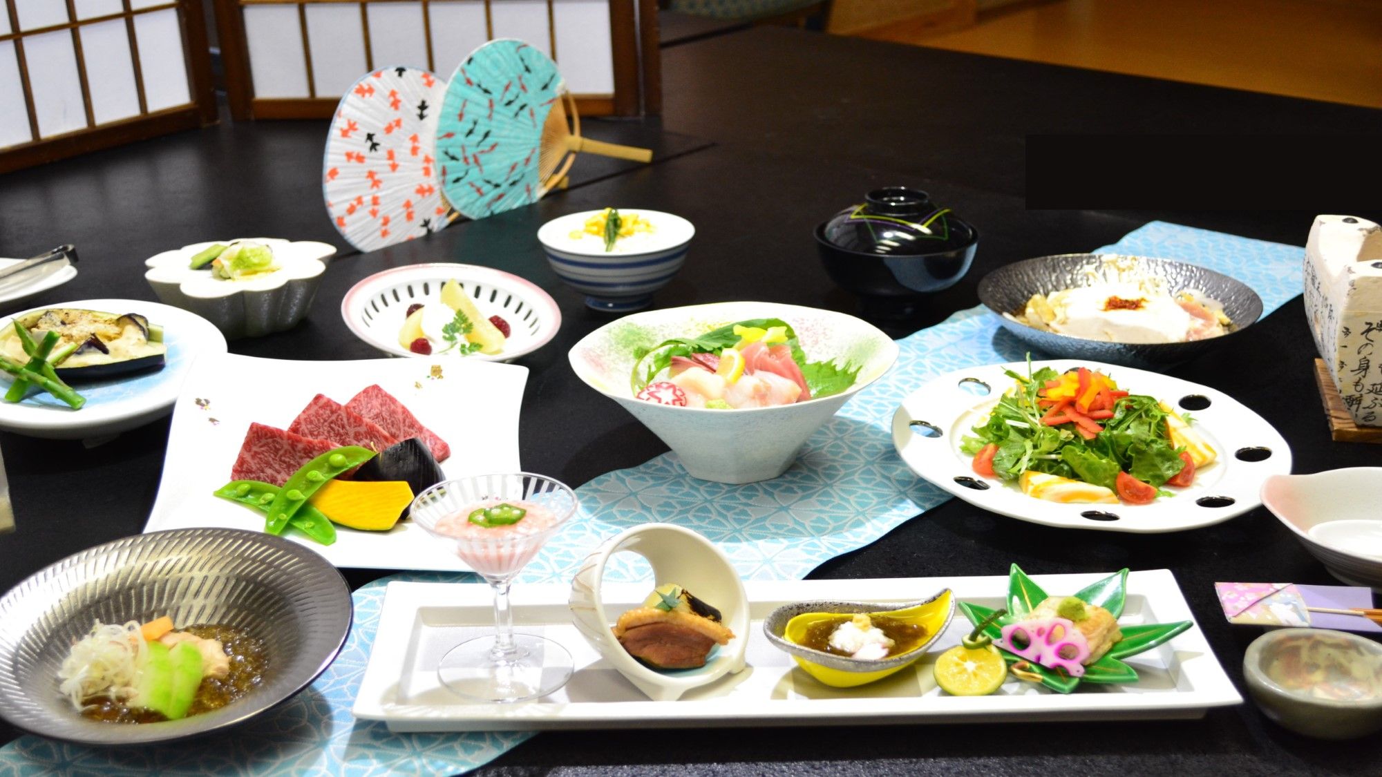 Diversos pratos em uma mesa, incluindo sushi, sashimi e outras especialidades da culinária japonesa.