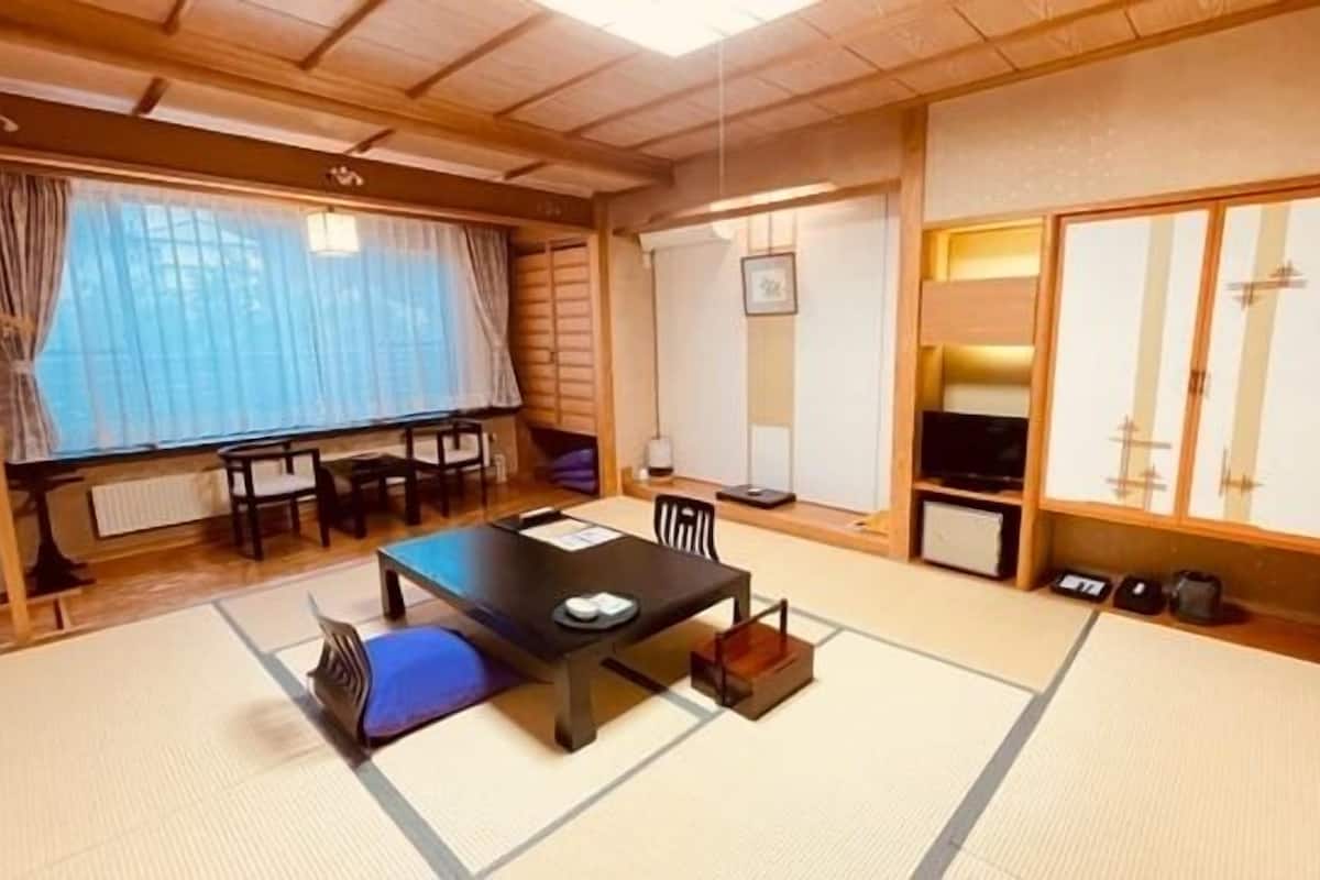 Een traditionele Japanse kamer met tatami vloerbedekking, een lage tafel en glijdende deuren.