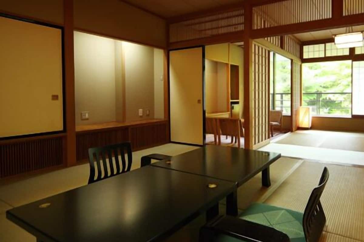 A traditional Japanese room with tatami flooring, a low table, and sliding doors.