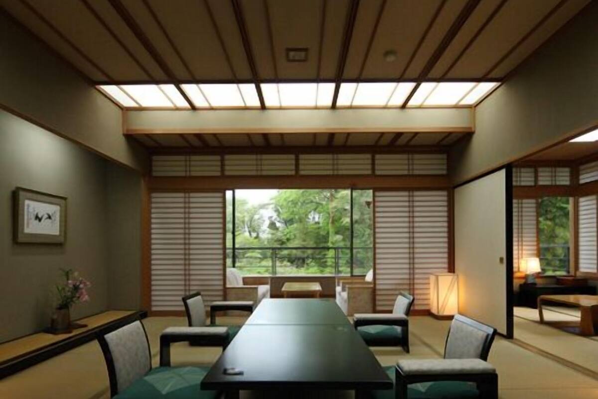 A traditional Japanese-style meeting room with tatami flooring, a low table, and sliding shoji screens.