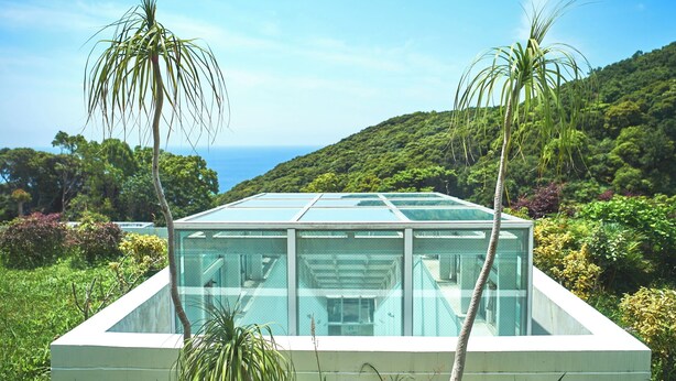 A modern glass house with a view of the ocean and lush greenery. - Ashizuri Thermae (Tosashimizu)