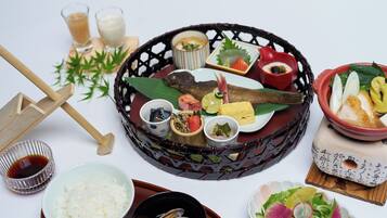 A traditional Japanese meal with various dishes and utensils on a table.
