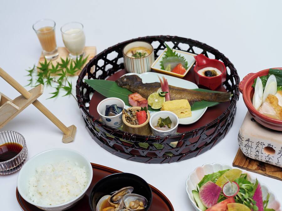A traditional Japanese meal with various dishes and utensils on a table.