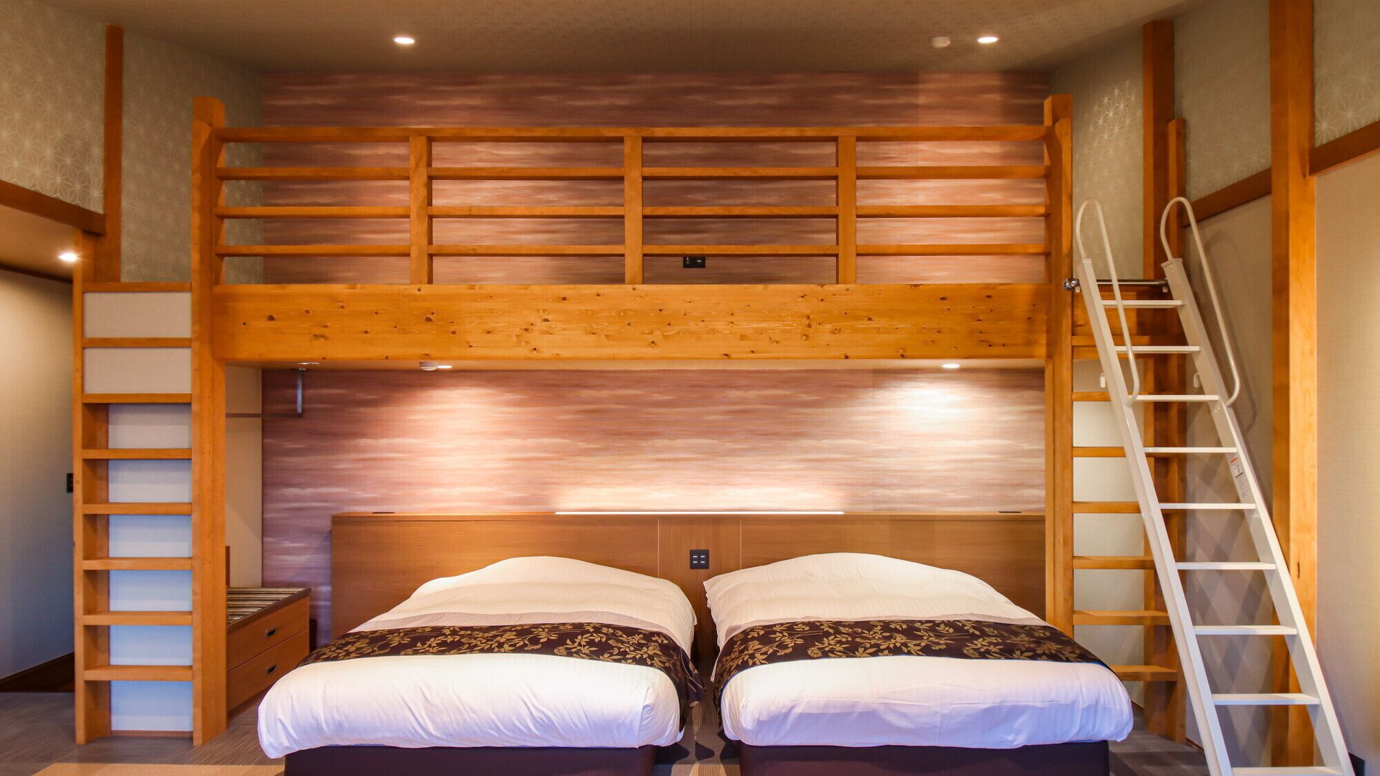 A bunk bed room with a wooden ladder, a small bedside table, and a wall-mounted light.
