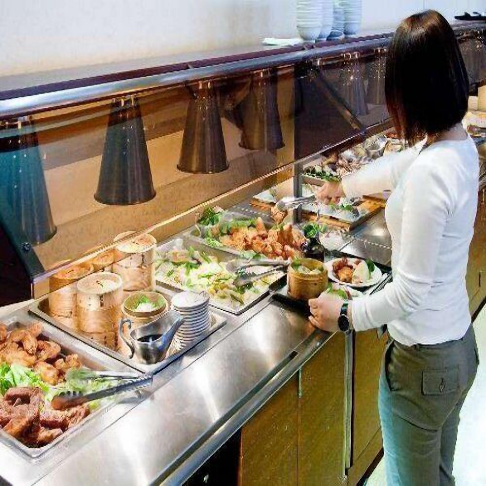 A buffet setup with various food items and condiments.
