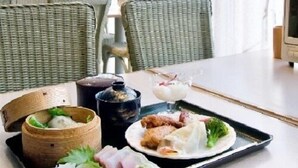 A dining table with a tray of food, including sushi, a bowl of soup, and a small dessert. - Hotel Taihei (Matsuyama)