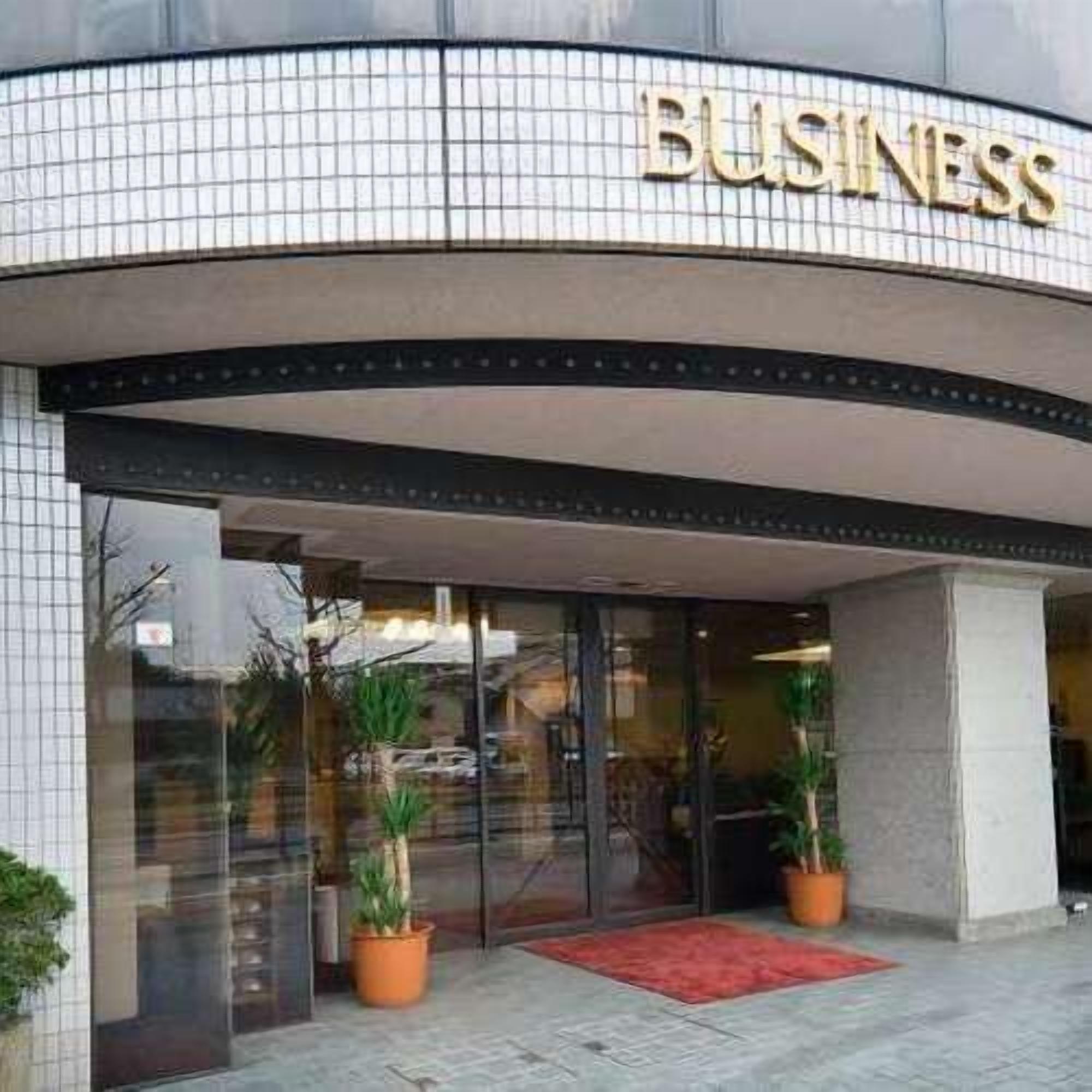 A building with a curved facade and the word "BUSINESS" prominently displayed above the entrance.