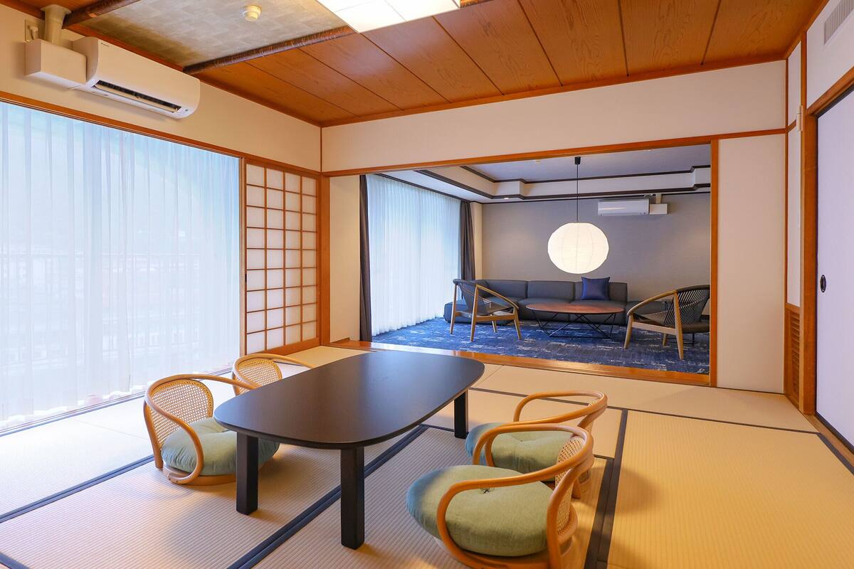 Ett traditionellt japanskt rum med tatamimattor på golvet, ett lågt bord och shojiskärmar.
